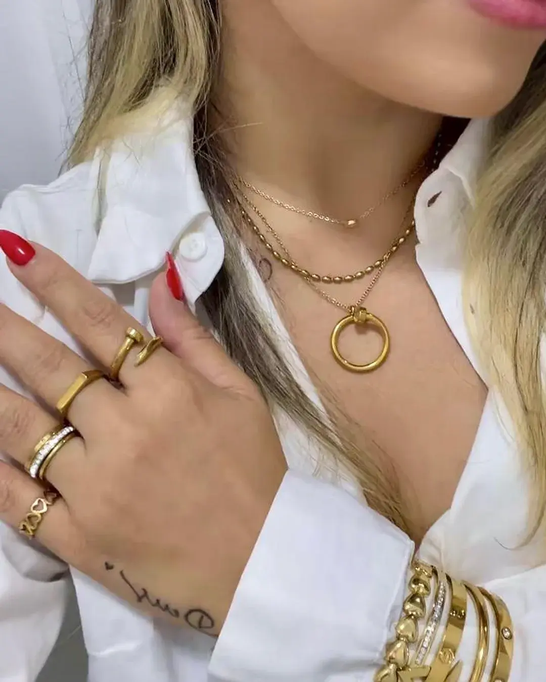 Dona da Vincent Acessórios usando colares, anéis e pulseiras douradas